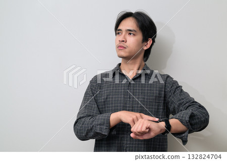 Portrait of handsome Young Asian Thai man using smartwatch against white background Portrait of handsome Young Asian Thai man using smartwatch against white background 132824704