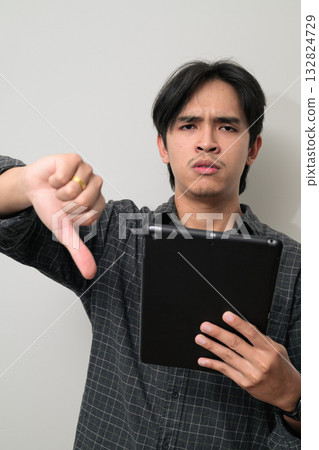 Portrait of handsome Young Asian Thai man using digital tablet computer against white background 132824729