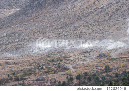 View of Mount Kusatsu-Shirane with crater walls and rising steam 132824946
