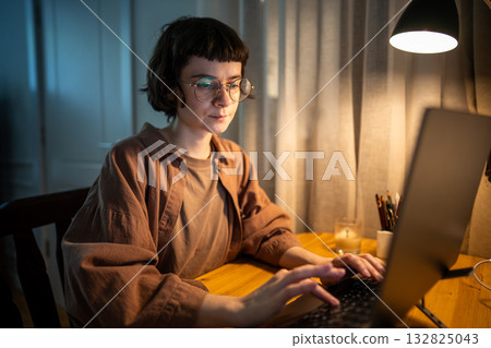 Stressed exhausted woman working late. Tired female typing on laptop night hours in stress at home Stressed exhausted woman working late. Tired female typing on laptop night hours in stress at home 132825043