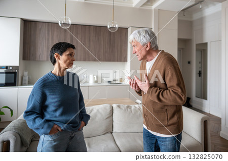 Enraged senior man yells at wife, tension erupt. Partners conflict, household stress in family Enraged senior man yells at wife, tension erupt. Partners conflict, household stress in family 132825070