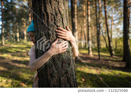 Woman hands hugging tree trunk with love in forest. Protecting nature, sustainable welfare Woman hands hugging tree trunk with love in forest. Protecting nature, sustainable welfare 132825086