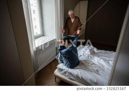 Mature wife overwhelmed by emotional pain sobbing on bed, partner stunned offering support at home Mature wife overwhelmed by emotional pain sobbing on bed, partner stunned offering support at home 132825167