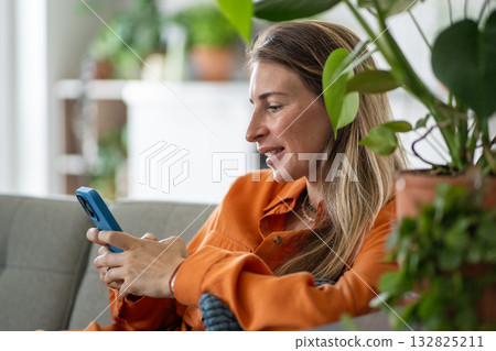 Middle-age woman actively texting message or typing comment intently concentrated on smartphone 132825211