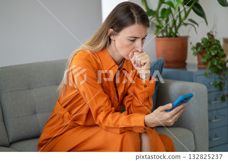 Middle-aged woman in speechless shock and anxiety reading receiving terrible news on smartphone Middle-aged woman in speechless shock and anxiety reading receiving terrible news on smartphone 132825237