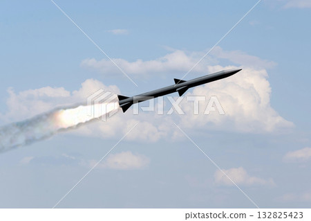A combat rocket is flying above the clouds, smoke and fire from the rocket. A combat rocket is flying above the clouds, smoke and fire from the rocket. 132825423