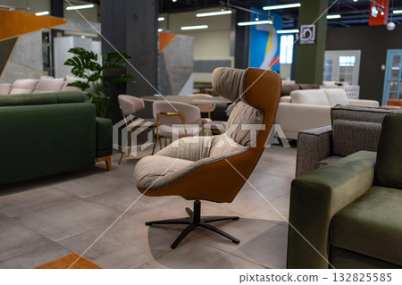 Armchair, furniture, showroom display. Modern stylish upholstered chair in a spacious retail store. 132825585