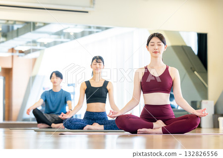 年輕男女在瑜珈館練習瑜伽 年輕男女在瑜珈館練習瑜伽 132826556