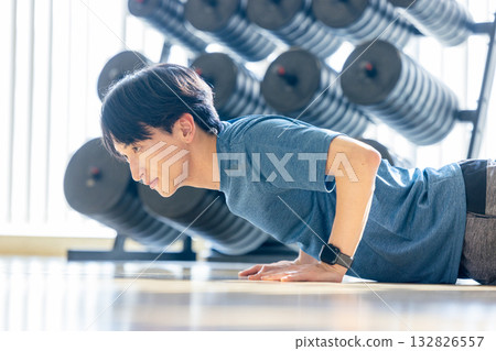 一名年輕男子在健身房做伏地挺身。 132826557