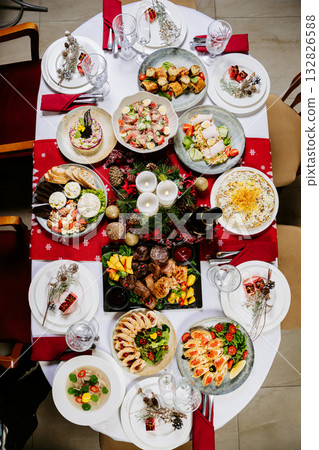 Festive Christmas dinner table with assorted gourmet dishes, salads, and holiday decor 132826588