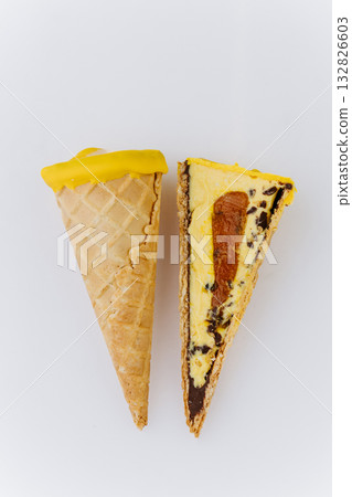 Sliced yellow ice cream cone with caramel and chocolate filling on white background Sliced yellow ice cream cone with caramel and chocolate filling on white background 132826603