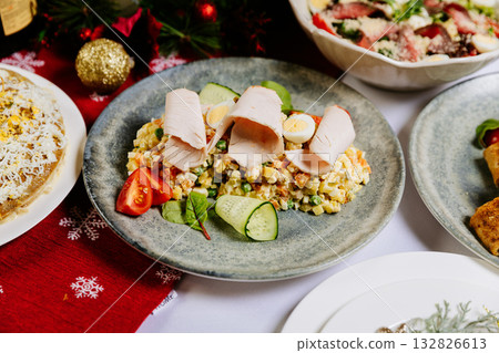 Traditional Olivier salad with turkey and vegetables on festive Christmas table 132826613