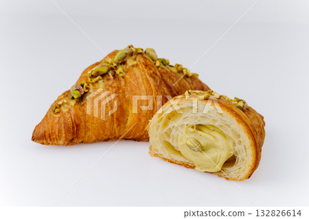 Fresh pistachio croissant with creamy filling on white background, gourmet bakery dessert Fresh pistachio croissant with creamy filling on white background, gourmet bakery dessert 132826614