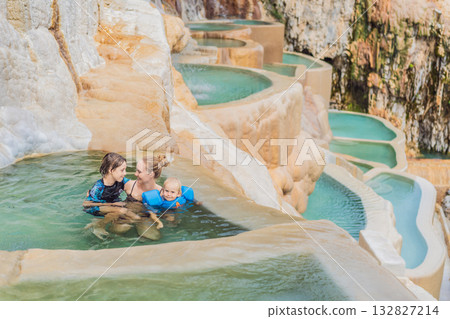 Mother with her toddler and teenage son bathing in the hot springs of Grutas Tolantongo, Mexico, enjoying family bonding, wellness, and outdoor adventure concept. 132827214