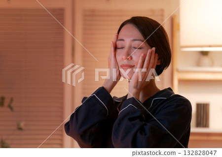 A woman moisturizing her skin at night 132828047