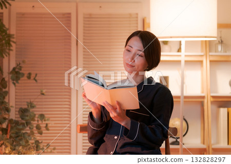 A woman reading in her room at night 132828297