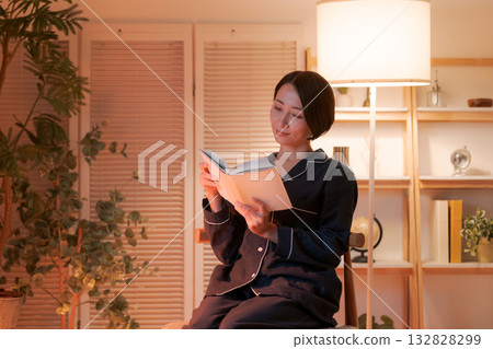 夜裡，一位女子在房間裡讀書。 132828299