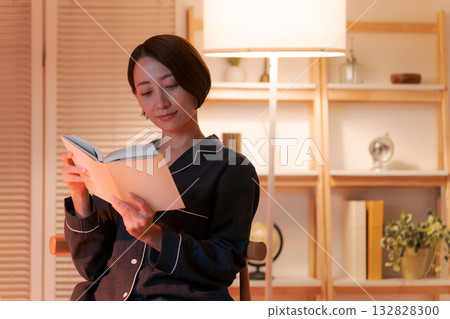夜裡,一位女子在房間裡讀書。 夜裡,一位女子在房間裡讀書。 132828300