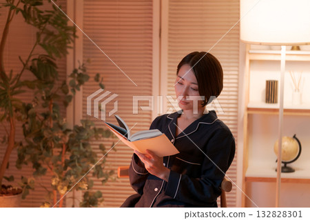 夜裡，一位女子在房間裡讀書。 132828301