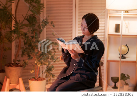 夜裡，一位女子在房間裡讀書。 132828302