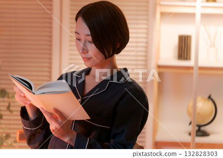A woman reading in her room at night 132828303