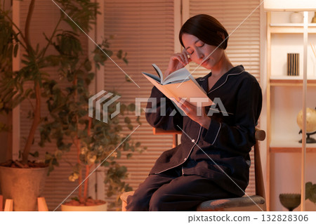 夜裡，一位女子在房間裡讀書。 132828306
