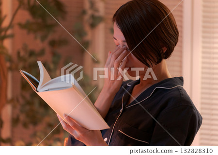 夜裡,一位女子在房間裡讀書。 夜裡,一位女子在房間裡讀書。 132828310