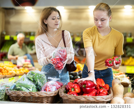 Two women choose bell peppers together 132828331