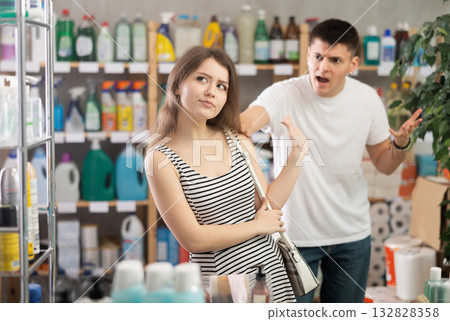Woman stands in a supermarket offended by a man Woman stands in a supermarket offended by a man 132828358
