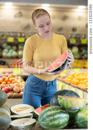 Teenage girl chooses watermelon in store Teenage girl chooses watermelon in store 132828366