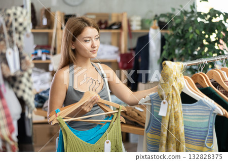 Girl customer choose tank top in store 132828375
