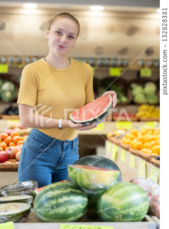 Young woman shopper choosing sliced watermelon in store 132828381