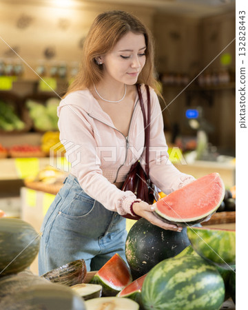 Young woman chooses watermelon in store 132828443