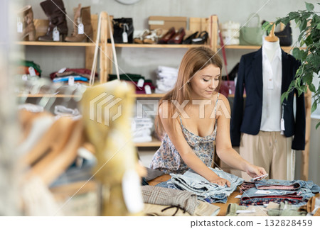Search and selection of new jeans in a clothing store for young girl 132828459