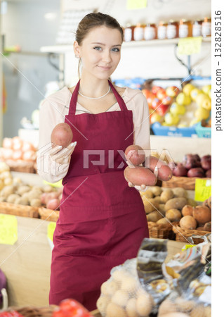 Woman seller in apron holding potatoes Woman seller in apron holding potatoes 132828516