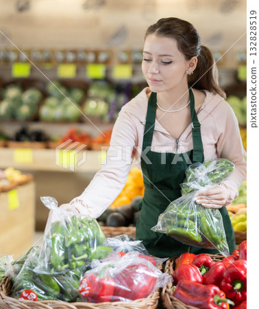 Woman seller putting green peas in a bag on the counter Woman seller putting green peas in a bag on the counter 132828519