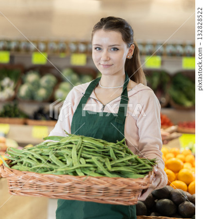 Young woman seller holding basket with green peas Young woman seller holding basket with green peas 132828522