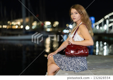 Evening portrait of girl against background of port in Vell in Barcelona. Yachts and boats Evening portrait of girl against background of port in Vell in Barcelona. Yachts and boats 132828554