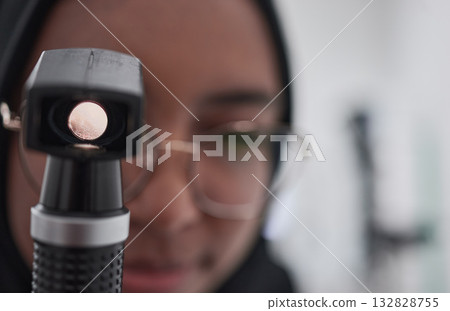 Eye exam, consulting and medical with muslim woman optometry tool for healthcare, vision and microscope for you. Ophthalmology, wellness and glaucoma test with girl and retinoscope for treatment 132828755