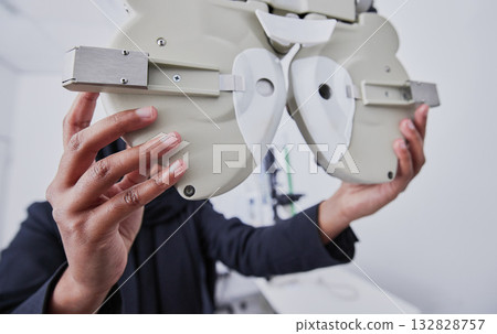 Optometry, machine and optometrist preparing for a eye test in the optic or healthcare clinic. Vision, ophthalmology and hands of a female optician with optical equipment for a exam in a store. Optometry, machine and optometrist preparing for a eye test in the optic or healthcare clinic. Vision, ophthalmology and hands of a female optician with optical equipment for a exam in a store. 132828757