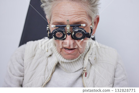 Eye exam, trial frame and senior woman in optometry clinic for vision test, eyesight and optical assessment. Ophthalmology, health and face of elderly patient with optician, optometrist and glasses Eye exam, trial frame and senior woman in optometry clinic for vision test, eyesight and optical assessment. Ophthalmology, health and face of elderly patient with optician, optometrist and glasses 132828771