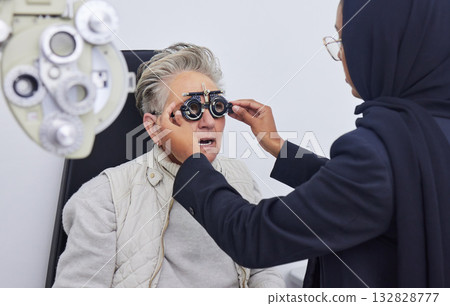 Eye exam, glasses and senior woman with optometrist in clinic for testing eyes, check eyesight and optical care. Vision, healthcare and Muslim optician with patient, optometry and medical tools 132828777