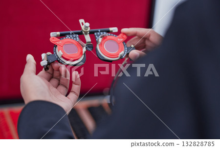 Glasses, lens and trial frame, hands with ophthalmologist tools, vision test with woman, healthcare for eyes and prescription. Optometry, eye care and optometrist, medicine and measurement Glasses, lens and trial frame, hands with ophthalmologist tools, vision test with woman, healthcare for eyes and prescription. Optometry, eye care and optometrist, medicine and measurement 132828785