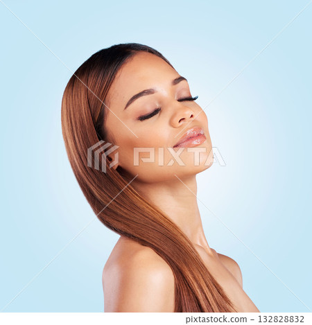 Face, skincare and hair care of woman with eyes closed in studio isolated on a blue background. Makeup cosmetics, beauty and young female model with salon treatment for growth, hairstyle and balayage 132828832
