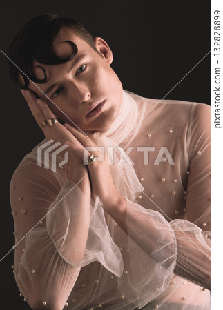 Gender neutral, vintage fashion and portrait of person with designer clothing and faux pearls in studio. Isolated, black background and lgbtq or gay model with jewelry and creativity and non binary Gender neutral, vintage fashion and portrait of person with designer clothing and faux pearls in studio. Isolated, black background and lgbtq or gay model with jewelry and creativity and non binary 132828899