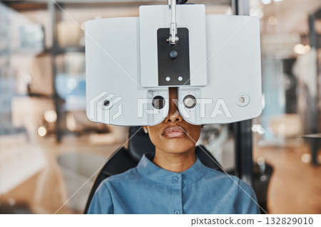 Vision, eye exam and black woman in optometry clinic for testing, eyesight and optical assessment. Healthcare, optometrist consultation and patient with medical equipment, phoropter and lens for eyes 132829010