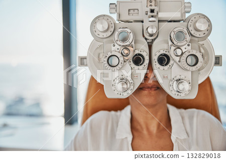 Vision, eye exam and woman in optometry test for wellness, eyesight and optical assessment. Healthcare, optometrist consultation and patient with medical equipment, phoropter and lens for eyes 132829018