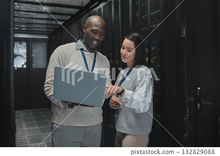 Business, black man and woman with laptop, servers and cyber security for connection, data analytics and conversation. IT specialist, female programmer and employees with device and cloud computing Business, black man and woman with laptop, servers and cyber security for connection, data analytics and conversation. IT specialist, female programmer and employees with device and cloud computing 132829088