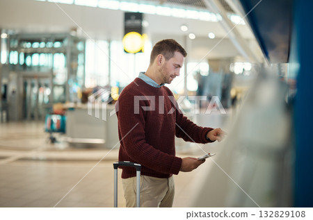 Travel, passport and man in airport, commute and opportunity for vacation, break and getaway. Tourism, male traveler and tourist with ticket, check in and ready for trip, international and document 132829108