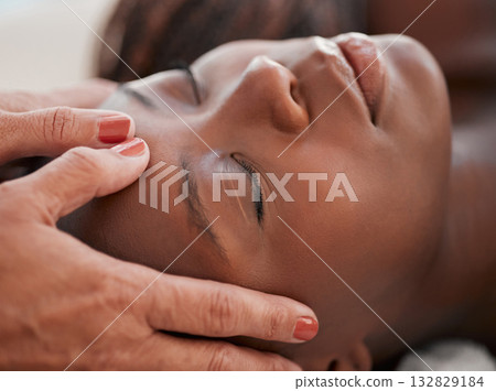 Skincare, beauty and black woman getting a facial massage for health, wellness and self care. Cosmetic, spa and calm African female sleeping while doing a luxury natural face treatment at a salon. 132829184